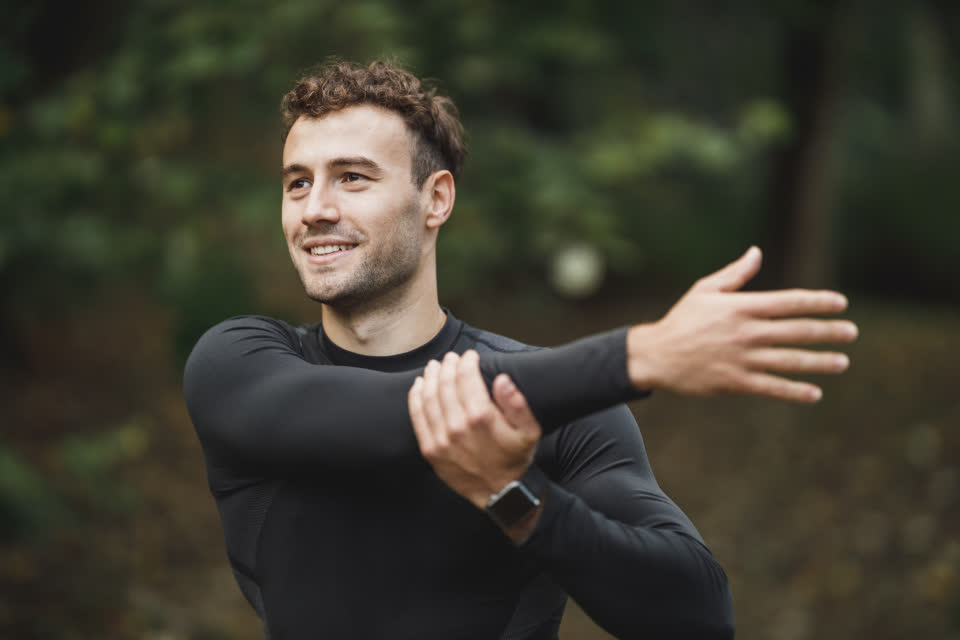 Personal trainer sorrindo durante o alongamento