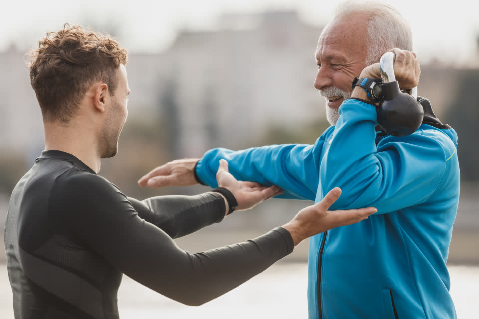 Personal trainer corrigindo o movimento de um aluno