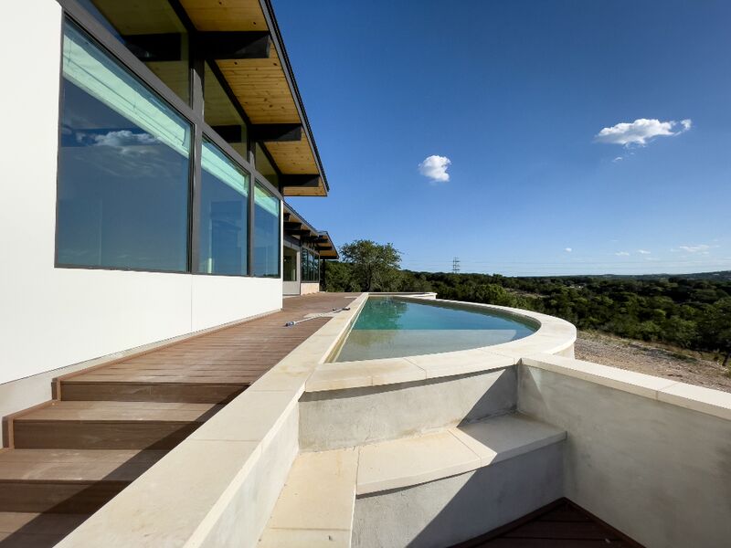 Casa com deck de madeira e piscina com vista para a mata