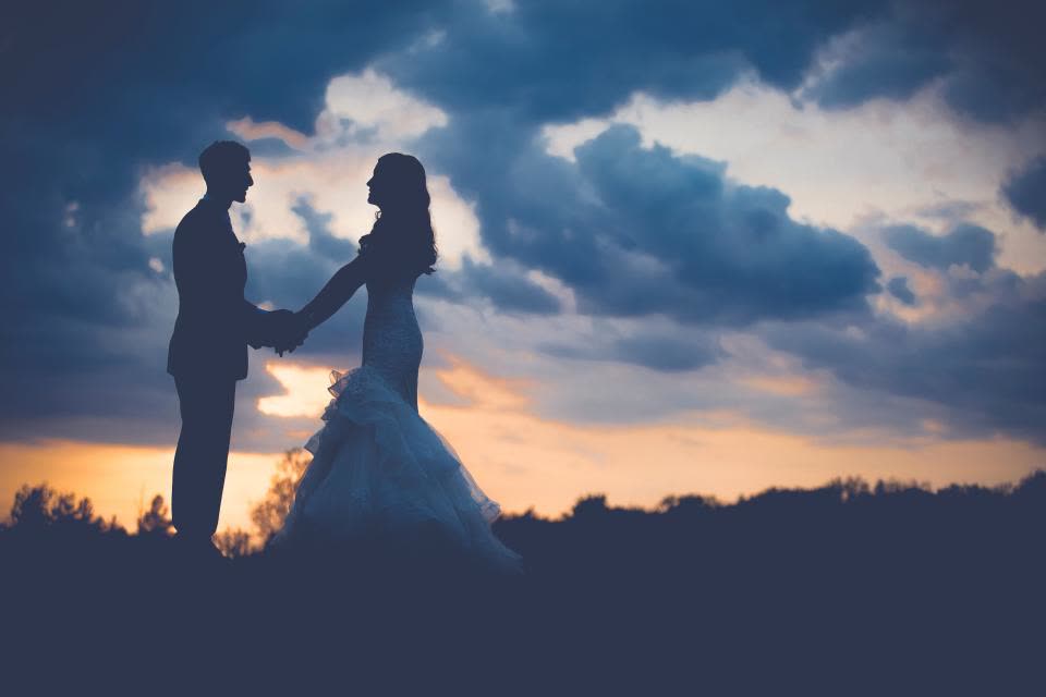 Silhueta de casal de noivos ao pôr do sol