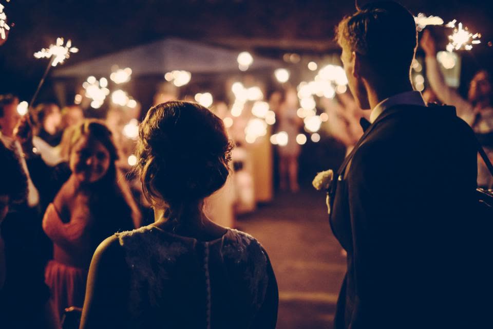 Convidados com estrelinhas acesas numa festa à noite